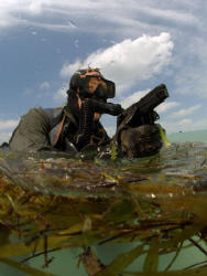 Navy SEAl exits the water during a training mission. by Andrew Mckaskle 